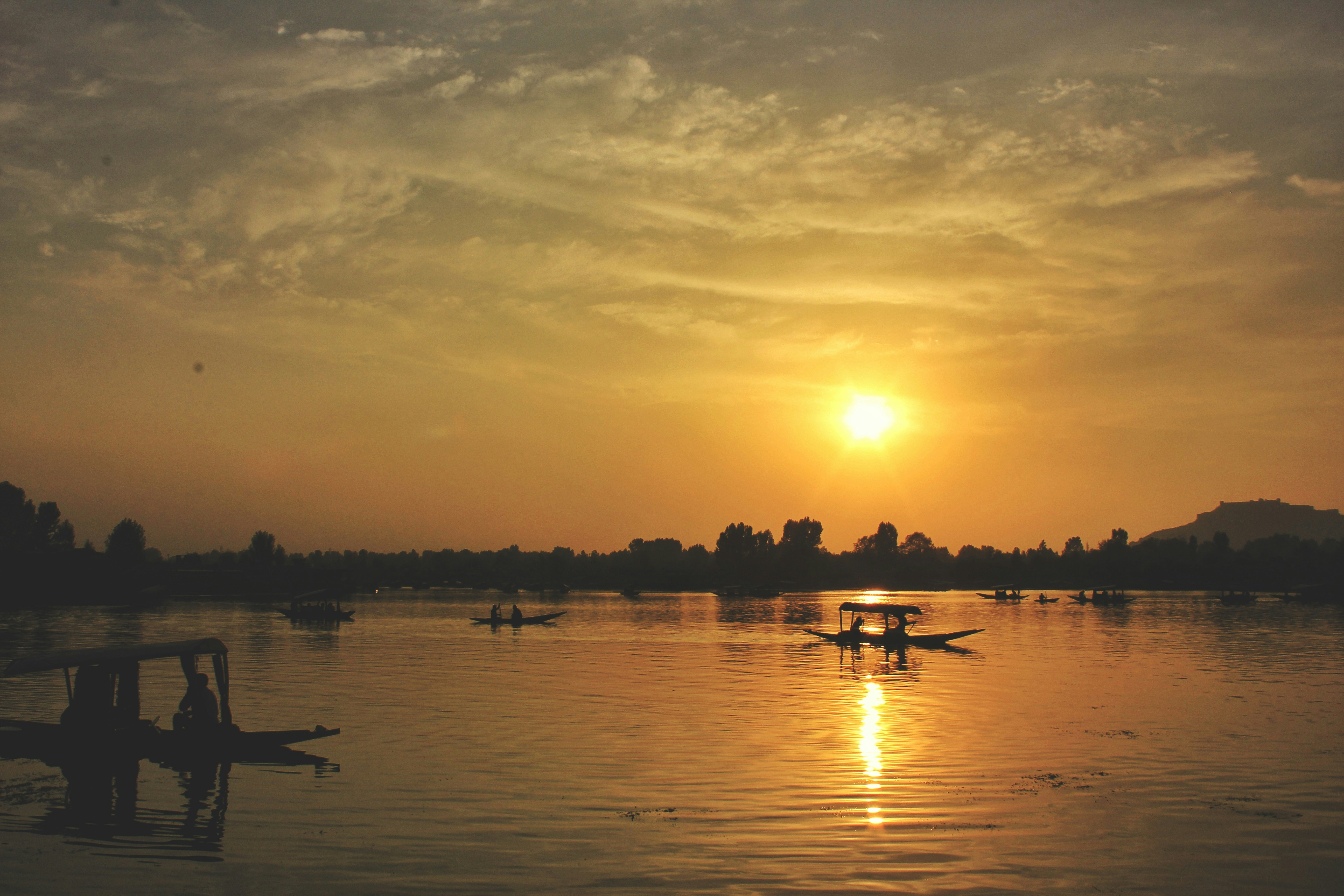 A wide-angle view of a serene lake reflecting the surrounding mountains.